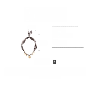 Detail view of leopard print fabric necklace with gold sun charms and 88cm length specs
