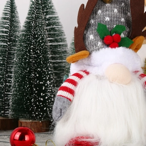 Close-up of a Christmas gnome doll with grey knitted hat, reindeer antlers, and berry detail