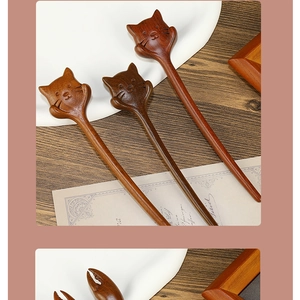 Detail of hand-carved sandalwood hair pin featuring cute cat and crab claw shapes