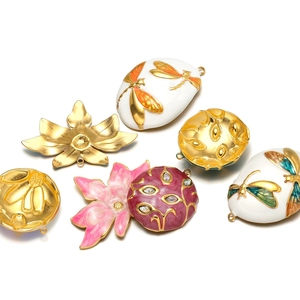 Detailed macro of gold plated stainless steel enamel dragonfly and flower pendants