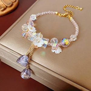 Detailed shot of crystal flower bracelet with gold chain and lavender faceted pendants