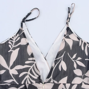 Women's V-neck dress with white leaf print on black crinkled fabric and adjustable straps