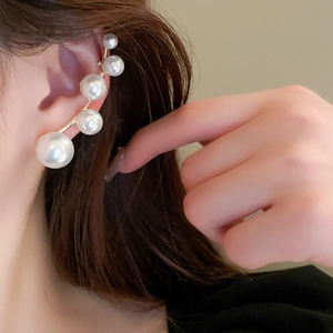 Close-up of gold ear cuff with five gradient white pearls on model ear