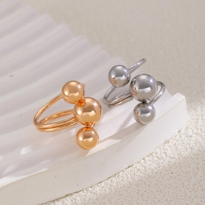 Vue macro détaillée de bagues ajustables minimalistes à trois billes métalliques dorées