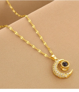 Detailed view of gold moon pendant with pavé zircons and central 100 languages projection stone