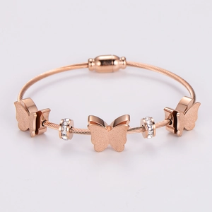 Detail of rose gold butterfly bracelet with white zircon and wire rope texture