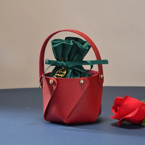 Detail of red leather Christmas apple gift bag with green velvet pouch and gold tag