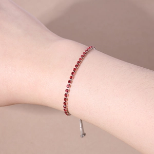 Detailed view of silver adjustable bracelet with red round cubic zirconia stones