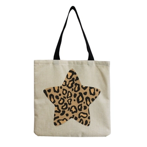 Detailed close-up of beige canvas shoulder bag featuring a leopard print star pattern