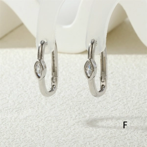 Macro shot of silver U-shaped hoop earrings featuring a marquise-cut white zircon