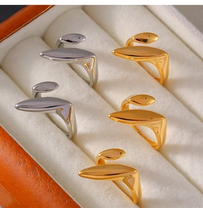 Macro shot of abstract teardrop rings in gold and silver finish on velvet tray