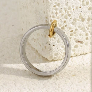 Détail d'une bague bicolore entrelacée dorée et argentée sur une pierre texturée