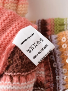 Nahaufnahme des Pflegeetiketts mit 100 % Polyester und sanften Waschanweisungen