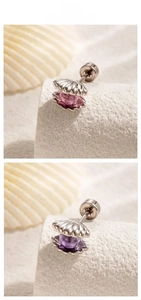 Macro detail of titanium steel shell earrings with pink and purple beads inlay