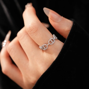 Macro shot of silver pig nose ring with pavé-set cubic zirconia on a model hand