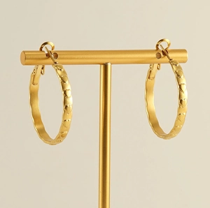 Dettaglio degli orecchini a cerchio placcati oro 18k con cuori in rilievo sul metallo