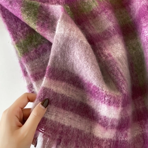 Close-up of pink and green plaid mohair scarf showing soft fuzzy texture and thick fringe