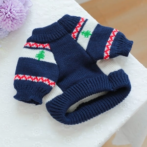 Detail of navy blue pet knit sweater with green tree pattern and soft texture