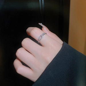 Gros plan d'une bague croisée argentée avec des accents en zircon au doigt