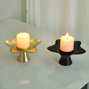 Nordic gold and black star candle holders with hammered texture on marble surface