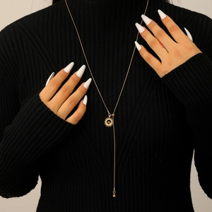 Detail of a vintage gold Y-shaped sunburst necklace with a tiger eye brown gemstone