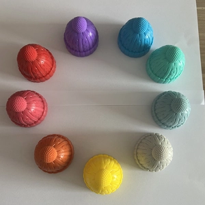 Multiple colorful silicone wine stoppers shaped like knit hats arranged on white paper