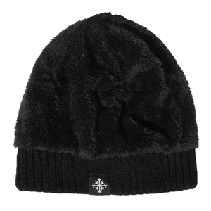 Detail of black winter knit hat with fluffy faux fur texture and snowflake patch