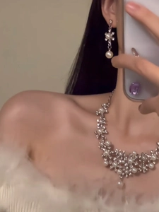 Mirror selfie showing silver flower jewelry set with pearls and rhinestones on a model
