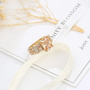 Detail view of 14K gold ring with large rectangle champagne stone and pavé diamonds