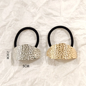 Detail view of gold and silver hammered metal hair ties with 5cm x 2.5cm dimensions