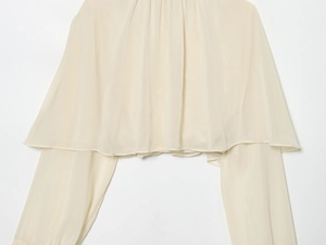 Detailed view of beige chiffon top featuring elegant pleated texture and lightweight fabric