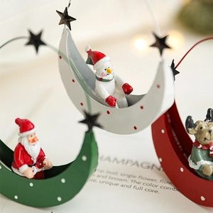 Three metal moon Christmas ornaments featuring Santa Claus Snowman and Reindeer