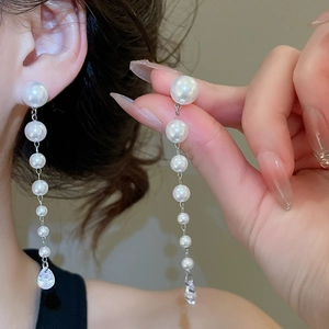 Detail of silver long tassel earrings with white pearls and crystal water drop pendant