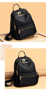 Close-up of black oxford cloth backpack with premium gold metal zippers and compartments