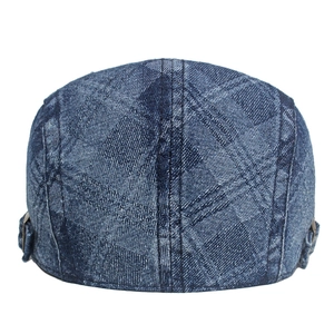 Detail of blue washed denim newsboy cap with diamond jacquard and metal side buckle