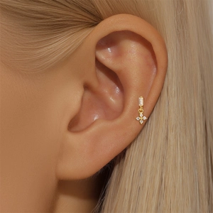 Detailed view of gold S925 silver ear stud with zircon flower pendant on ear