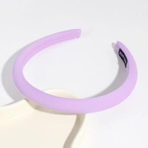 Detail of light purple fabric headband with handmade label on white ceramic tray