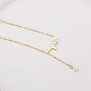 Détail du collier tulipe doré avec incrustation de nacre et élégant pendentif perle