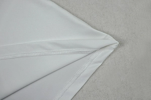 Close-up of white dress showing high-quality stitching and textured fabric details