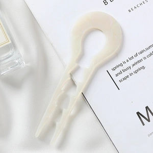 Detailed close-up of U-shaped hair fork showing non-slip teeth and marble finish