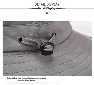 Detail view of adjustable drawstring buckle on a breathable grey sun hat with neat stitching