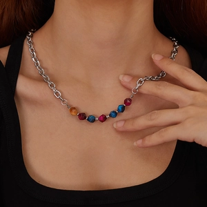 Close-up of silver chunky chain necklace with colorful faceted natural stone beads on a model