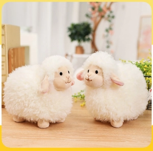 Close-up of two cute plush white sheep dolls showing soft long faux fur texture and details