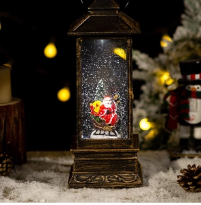 Close-up of bronze Christmas lantern snow globe with Santa Claus and festive warm lights