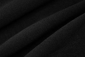 Close-up of black knitted fabric showing fine texture and soft drape of the cardigan