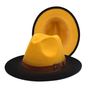 Detail of two-tone wool fedora with yellow crown, black brim, and brown leather belt buckle