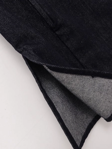 Detailaufnahme der dunkelblauen Denim-Baumwolltextur und der hochwertigen Saumverarbeitung