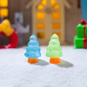 Miniature luminous resin Christmas trees in blue and green on a snowy landscape base