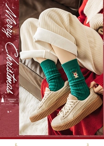 Détail de chaussette de Noël en tricot vert avec broderie cerf et décor festif