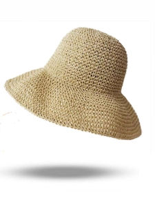 Dettaglio ravvicinato della trama intrecciata a mano del cappello da sole in paglia beige